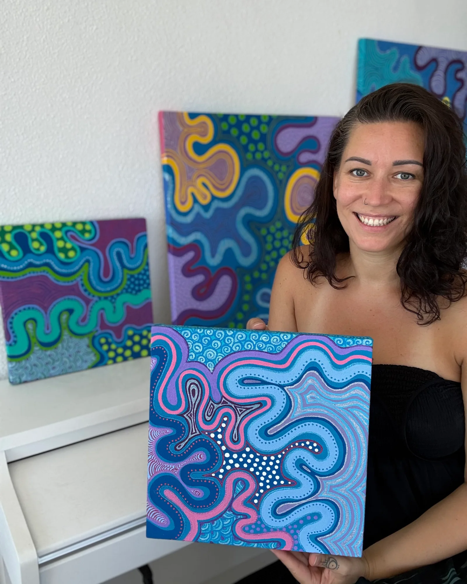 Paula Figura mostrando una de sus obras de Sunrisa Art