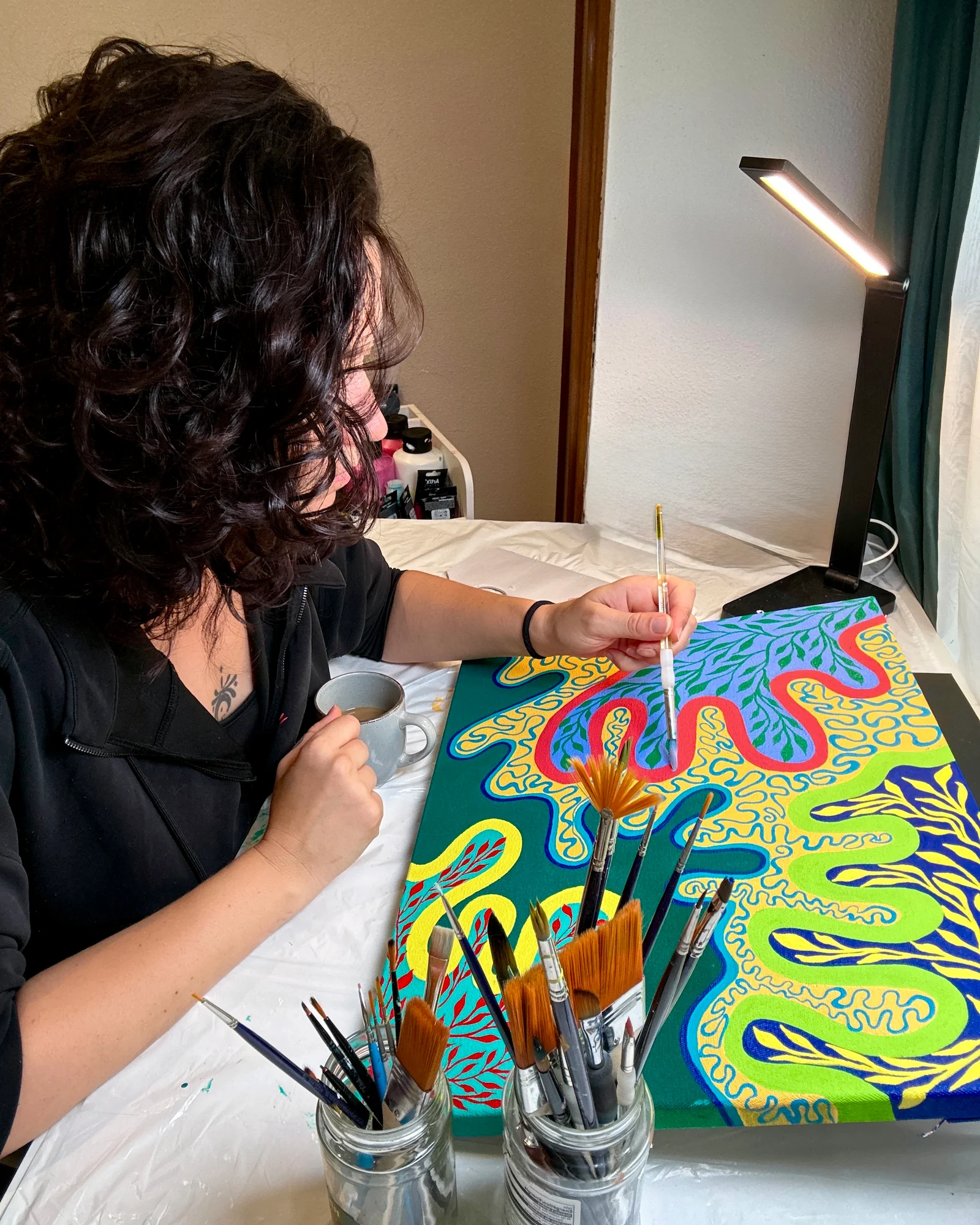 Paula Figura pintando una obra en su estudio de Sunrisa Art.